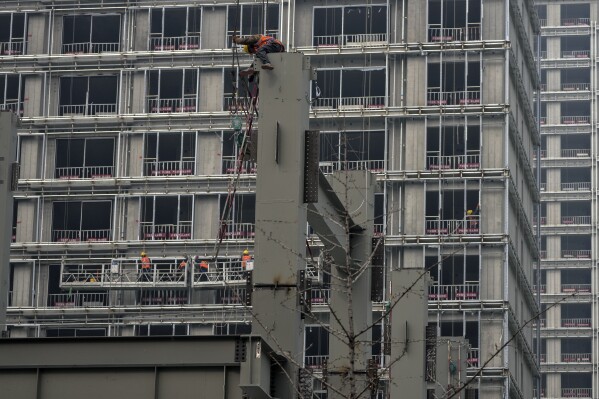 Employees with the installment platform in window new residences are still built in Beijing on March 1, 2025. (AP photo / Andy Wong)